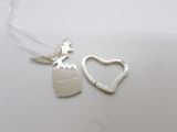 silver heart shaped bottle openers with a ribbon on a white table