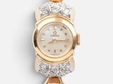 a close up of a gold and diamond watch on a white background