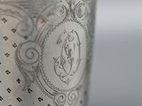 close up of a silver cup with a monogram on it