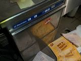 Plusieurs sacs de nourriture sont posés sur un tapis roulant dans une cuisine