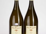 deux bouteilles de vin posées l'une à côté de l'autre sur une surface blanche