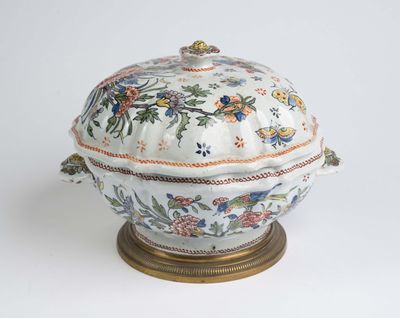 une soupière blanche et dorée ornée de fleurs