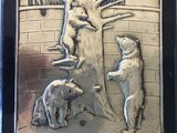une plaque métallique sur laquelle figurent un chien et un ours