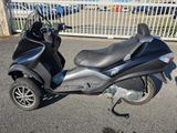 un scooter garé devant une clôture dans un parking