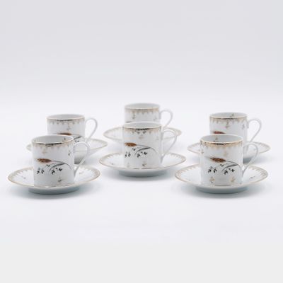 quatre tasses et soucoupes sont posées sur une surface blanche