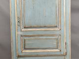 une vieille armoire bleue avec une porte et un tiroir au-dessus