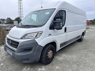 La camionnette blanche est garée sur un parking près de l'eau.