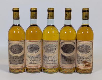 quatre bouteilles de vin posées les unes à côté des autres sur une surface blanche