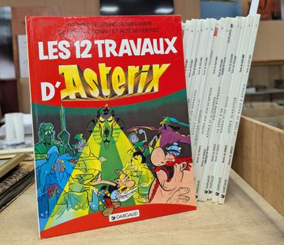 un livre posé sur une table, devant une pile de livres