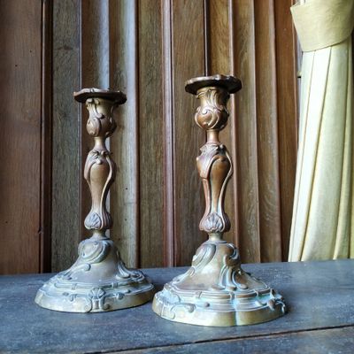 deux bougies posées sur une table devant un rideau
