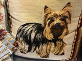 a pillow with a dog on it next to a pair of brown shoes