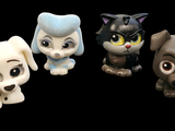 three little dogs and a cat figurines on a black background