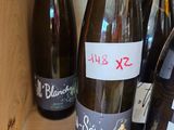 several bottles of wine are on a shelf with labels on them