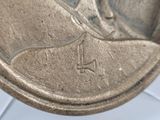 a close up of a metal plate with a sailboat on it