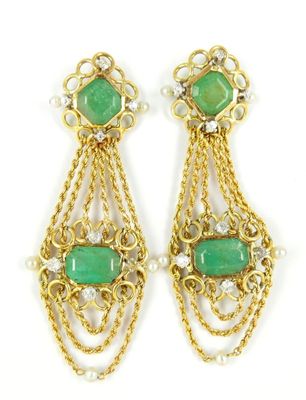une photo d'une paire de boucles d'oreilles ornées de pierres vertes et de perles