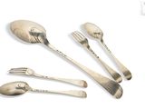 a silver spoon, fork, and spoon rest on a white surface