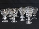 six crystal wine glasses are lined up on a black background