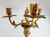 a gold candelab with two flowers on it