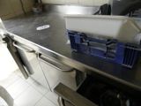 plan de travail en acier inoxydable dans une cuisine professionnelle, avec des bacs bleus
