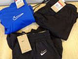 trois paires de shorts Nike noirs et bleus posés sur un parquet
