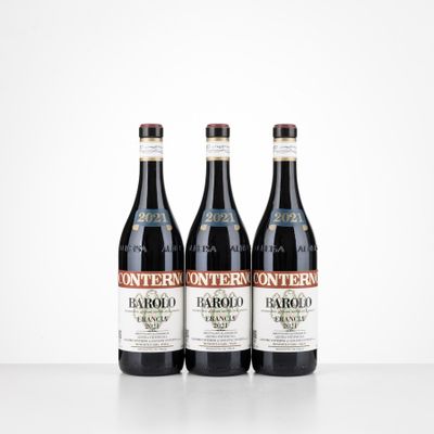 three bottles of red wine sit on a white surface