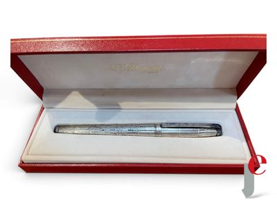 un stylo argenté dans une boîte rouge posée sur une surface blanche