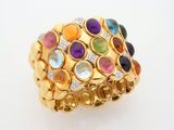 a close up of a gold ring with multi colored stones