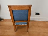 a small wooden chair with a blue seat in the corner of a room