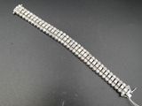 gros plan d'un bracelet en argent sur une surface noire