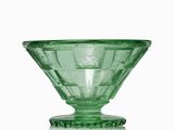 un saladier en verre vert posé sur une table blanche