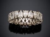 a white gold ring with five pear shaped diamonds on a black surface