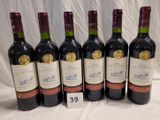 six bottles of wine are lined up in a row on a table