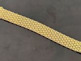 a close up of a gold bracelet on a black surface