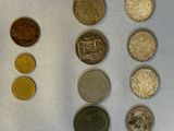 Plusieurs pièces de monnaie différentes sont disposées en rangée sur une surface blanche