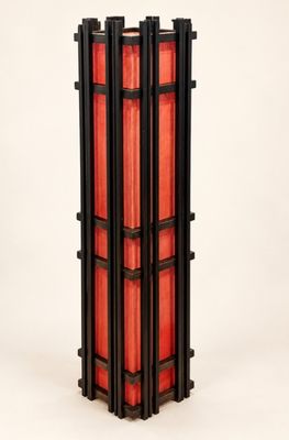 une image représentant une grande lampe en bois et en verre rouge