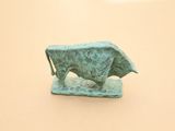 une petite statue de taureau posée sur une table