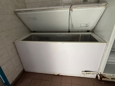 un congélateur coffre blanc posé dans le coin d'une pièce