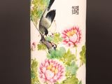 a vase with a bird and flowers on it on a table
