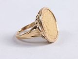 a close up of a gold ring with a coin on it