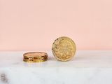 a close up of two gold coins sitting on top of a marble counter