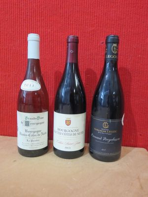 trois bouteilles de vin sont alignées sur une table