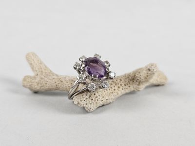 an amethorate and diamond ring on a piece of coral
