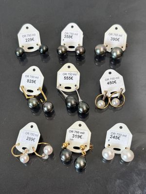 six paires de boucles d'oreilles en perles noires et blanches, avec leurs étiquettes de prix