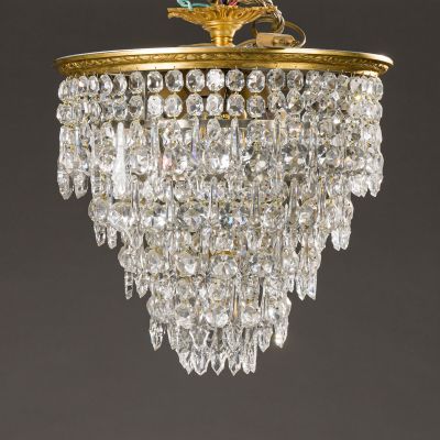 a gold plated chandelier with crystal drops hanging from the ceiling