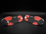 a pair of red and black shoes on a black surface
