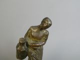 statue of a woman holding a bag on a marble base