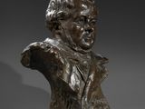 a bronze bust of a man wearing a suit and tie