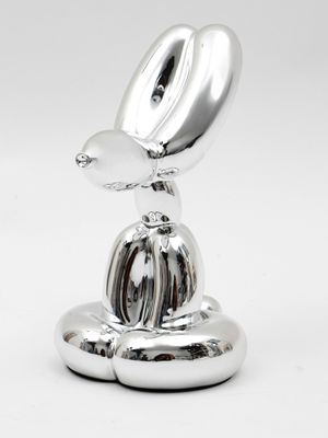 une sculpture en argent représentant un oiseau perché sur un objet métallique