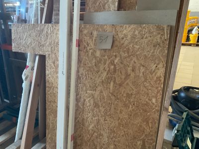 several pieces of plywood are stacked on top of pallets in a warehouse