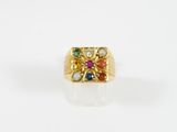 gros plan d'une bague en or avec des pierres multicolores